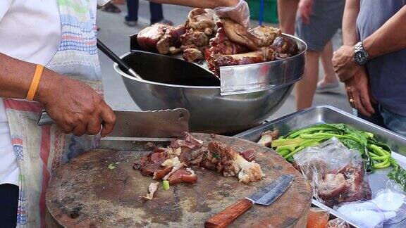 一名泰国男子将熟肉切成薄片准备在泰国街头食品市场出售近距离