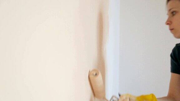 女人在粉刷房间的墙壁