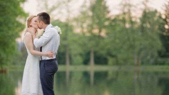 新娘和新郎在湖边接吻