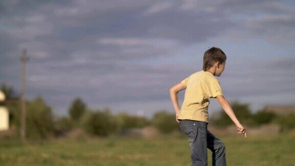 快乐的男孩在夏天的田野上奔跑快乐的青少年在乡村的绿色草地上跳跃