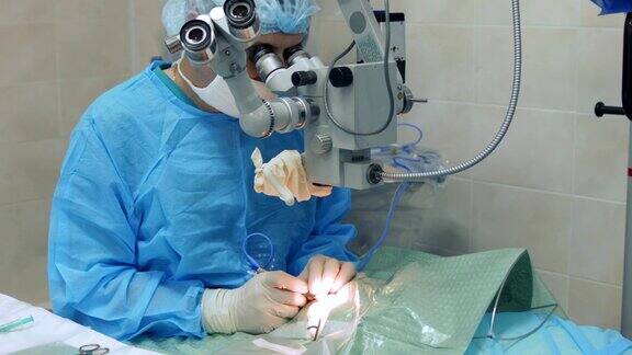 显微外科医生通过显微镜操作眼睛