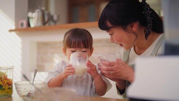 妈妈和她的小女儿喜欢在家吃沙拉和喝奶昔