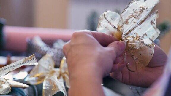 女性的手用金色丝带制作圣诞装饰