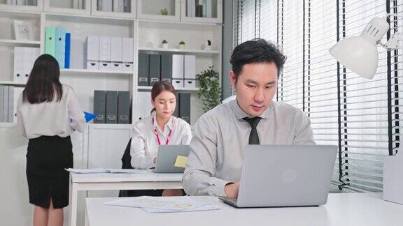 一群亚洲迷人的商业人士在办公室工作商人和女职工坐在桌子上用笔记本电脑工作为企业的公司项目策划