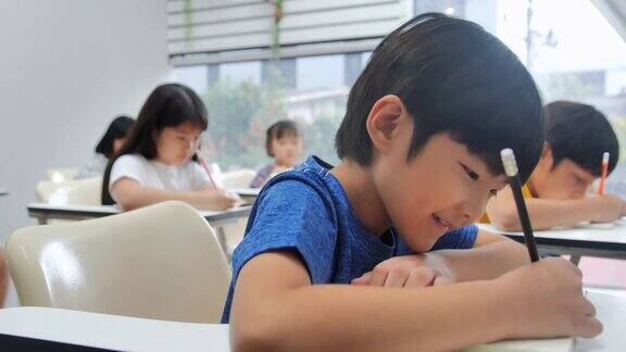小学生们在教室里用笔记本写字孩子们在上课可爱的孩子在做作业上学的孩子在桌前学习孩子的教育回到学校教育