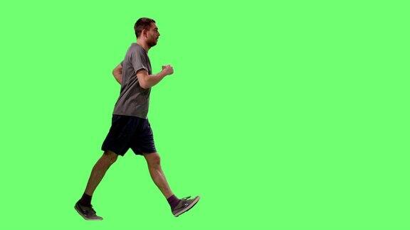 一名男子在t恤运动行走在模型的绿色屏幕在背景