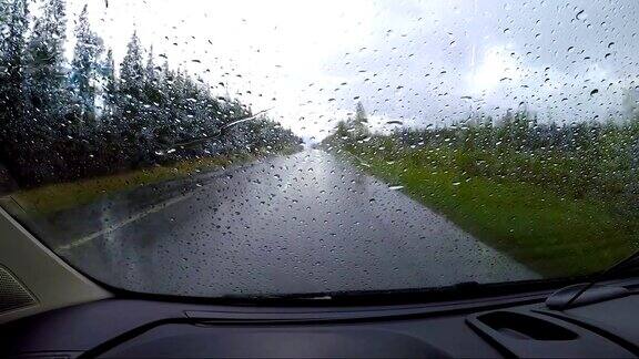 从雨中看汽车在潮湿的道路上行驶在挪威的路上驾驶汽车