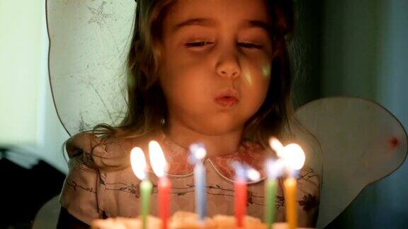 小女孩吹灭生日蛋糕上的蜡烛特写镜头缓慢的运动