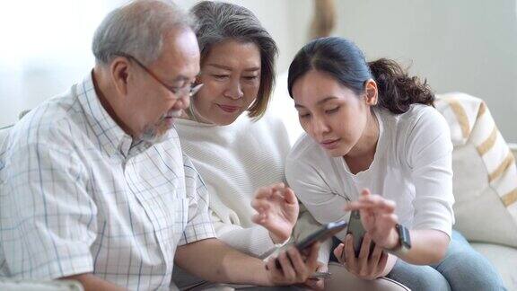 老年夫妇学习技术智能手机与女儿教学
