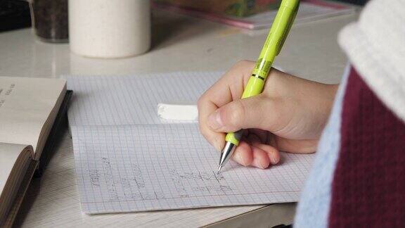 一个少年用铅笔在笔记本上写字