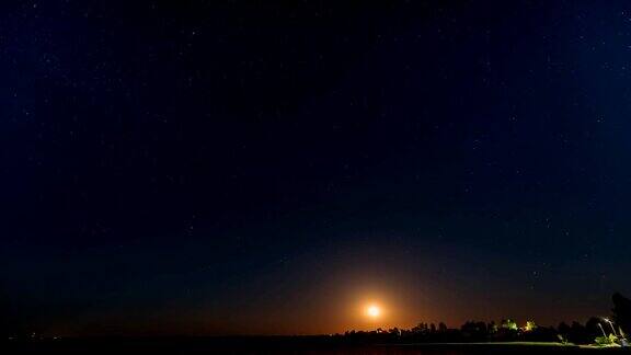 东欧白俄罗斯村庄上空月亮升起的时间间隔白俄罗斯乡村的房子在夏天的星夜