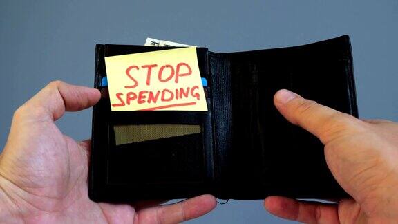 男人打开钱包上面写着“停止消费”浪费金钱