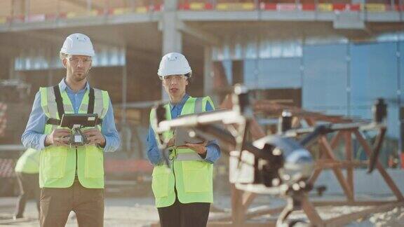 两名专家在建筑工地控制无人机建筑工程师和安全工程检查员驾驶无人机在商业建筑施工现场控制设计和质量