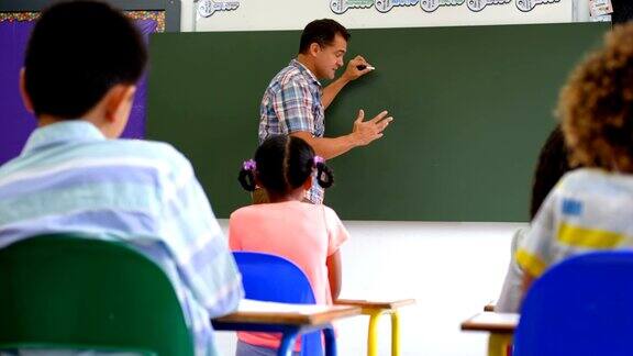 白人男老师在教室的白板上教学生的侧视图