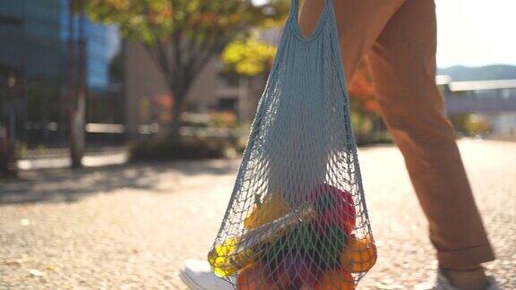 一名日本妇女在滋贺市的街道上使用可重复使用的棉网袋