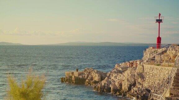 亚得里亚海的岩石海岸尽头有一座灯塔和一个码头