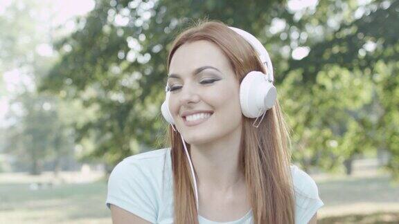 公园里戴着耳机的年轻女子