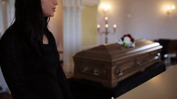 悲伤的女人和棺材在教堂的葬礼上