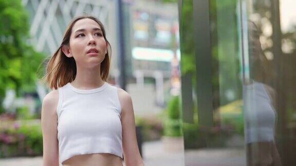 4K年轻亚洲女子肖像走在城市街道