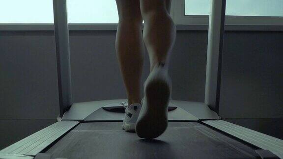 女孩的美腿在跑步机上跑