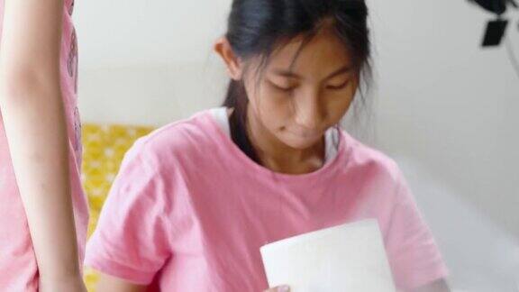 快乐的亚洲儿童收到商品从网上购物和拆包新电灯靠近窗户在家里生活方式