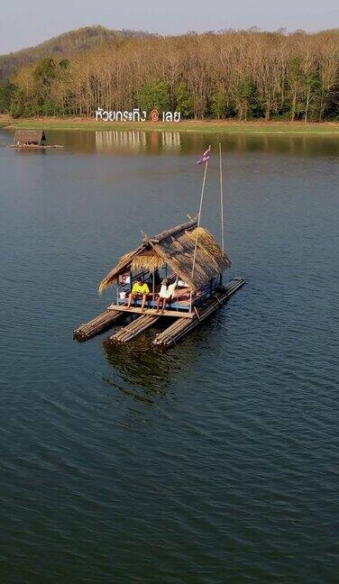 在泰国东北部伊桑地区的怀克拉廷湖男女在竹筏上