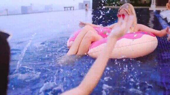 亚洲年轻女子放松在豪华酒店温泉游泳池享受美丽近距离观察女性在城市酒店享受夏季旅行在充气床垫上穿着比基尼的度假女人慢镜头