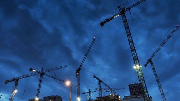 黑暗中起重机照亮的建筑工地城市在日落之后