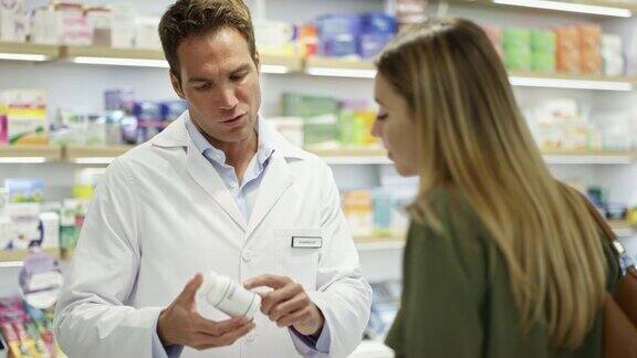 药剂师在药店向顾客解释药品