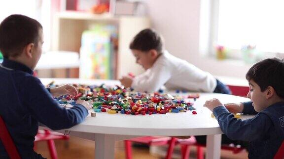 幼儿园的男孩在私立学校的游戏室玩塑料积木