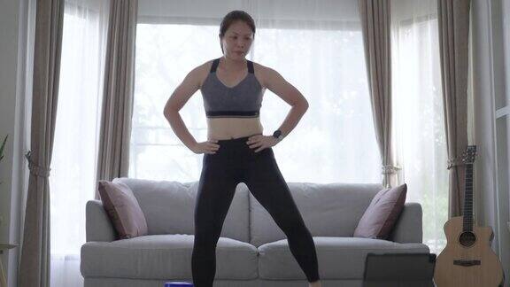 女性在家平板电脑上锻炼和练习脂肪燃烧