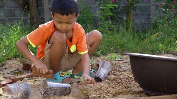 一个亚洲男孩在自家花园里种树