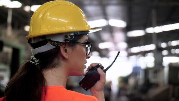 工程师们为工业工人使用机器在工厂工作时戴安全帽和反光背心