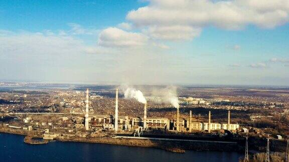 鸟瞰图的烟从电厂的管道在河岸