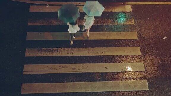 俯视图;行人人群在雨夜穿过人行横道