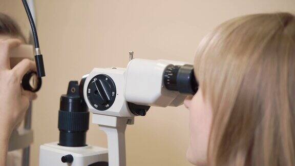 医生从事用生物显微镜检查孩子的眼睛