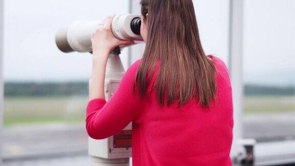 游客用双筒望远镜观看