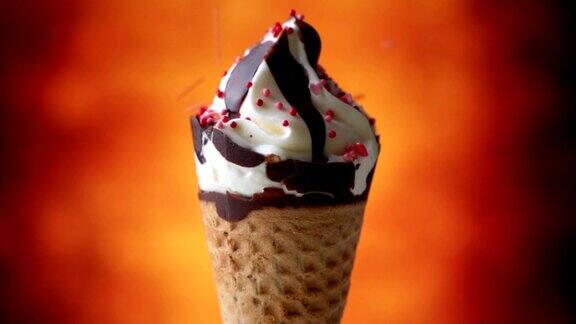 冰淇淋特写五彩缤纷的雪花洒在冰淇淋上华夫筒冰淇淋棕色背景旋转