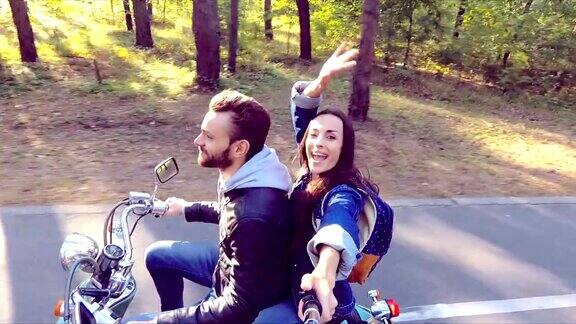 一对骑摩托车的夫妇Selfie-stick射击缓慢的运动