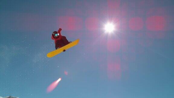 镜头光晕:极限滑雪板运动员握着滑板在空中旋转