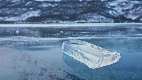 浮冰在冰面上旋转映衬着令人惊叹的山景缓慢的运动镜头移到了冰的后面冰在冰上旋转有神奇的裂缝非常漂亮
