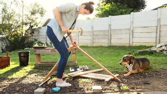 一个妇女在自家后院手工搭建一个种植箱