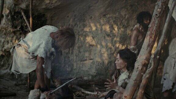 穿兽皮住在山洞里的采猎部落准备食物营火处理兽皮工作打猎快乐的尼安德特人家庭在人类文明的黎明