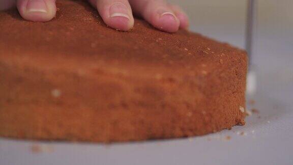 糕点师用特制的切刀将烤好的蛋糕切成平铺一层