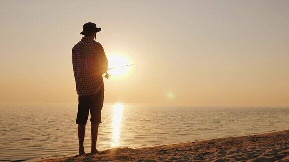 日落时分一个年轻人在风景如画的湖边钓鱼