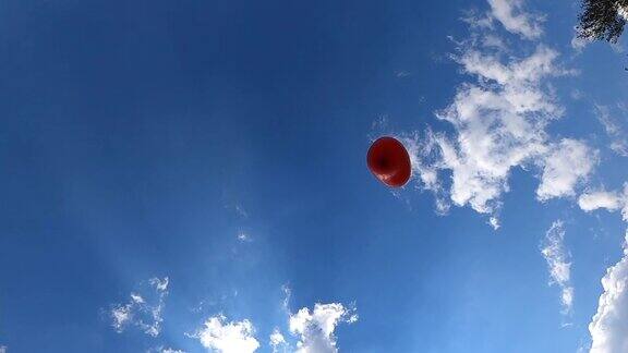 红色的心形气球在蓝色的天空中飞翔爱情象征着情人节爱的自由观念