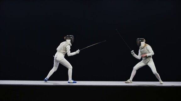 两名女击剑手在一场比赛中进行剑击