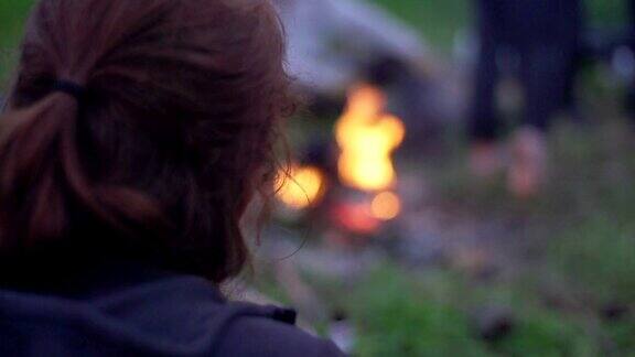在炉火旁取暖的女人野营