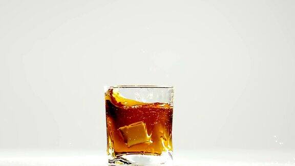 两块冰块掉进波旁威士忌酒杯里慢动作