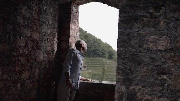 一个老人从城堡的墙头往外看